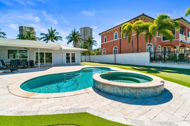 view of swimming pool featuring french doors, a patio area, a pool with connected hot tub, and fence