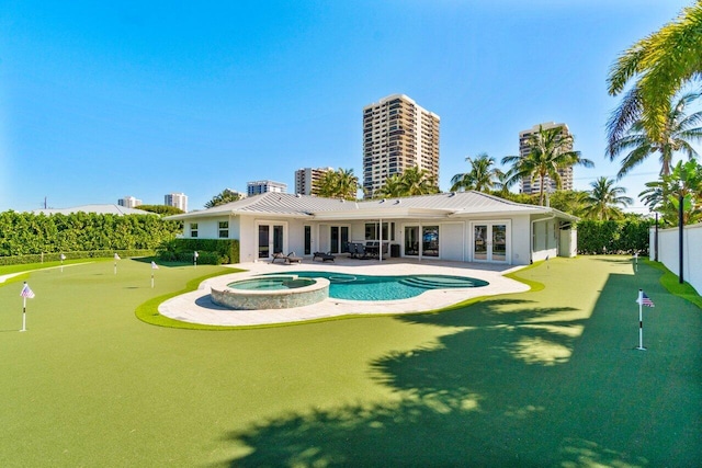 back of house with a patio area, french doors, a pool with connected hot tub, and fence