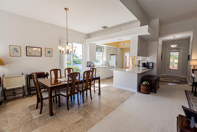 dining area featuring visible vents, baseboards, and ceiling fan with notable chandelier