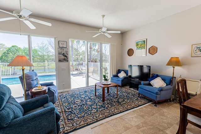 living room with a textured ceiling and a ceiling fan