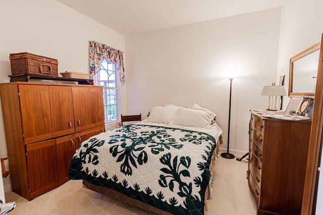 bedroom featuring light carpet and baseboards