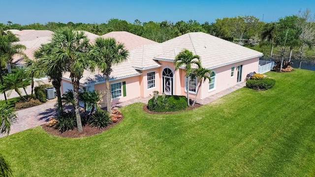 view of front of house with a tile roof, decorative driveway, a front yard, and stucco siding