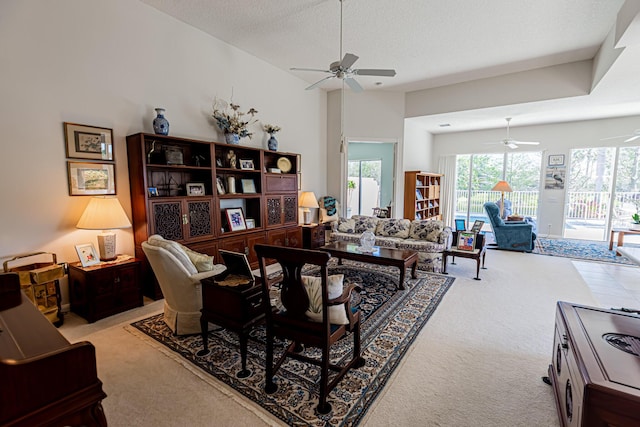 carpeted living area featuring a textured ceiling and ceiling fan