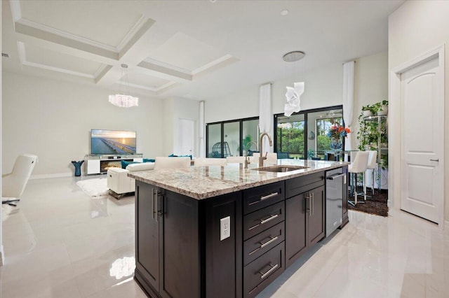 kitchen with decorative light fixtures, light stone counters, coffered ceiling, and a sink