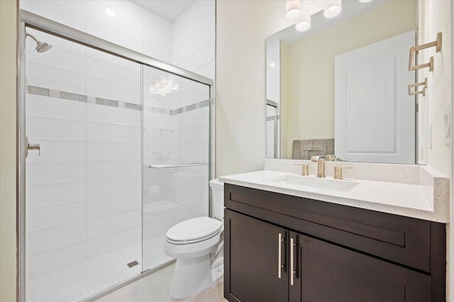 bathroom featuring tile patterned floors, vanity, toilet, and a shower stall