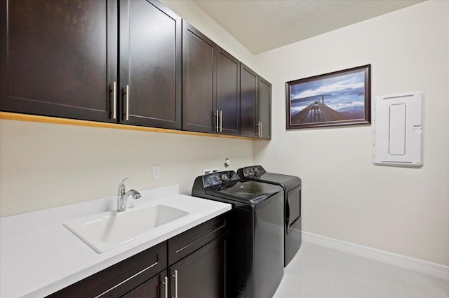 laundry room with baseboards, electric panel, cabinet space, a sink, and washer and dryer