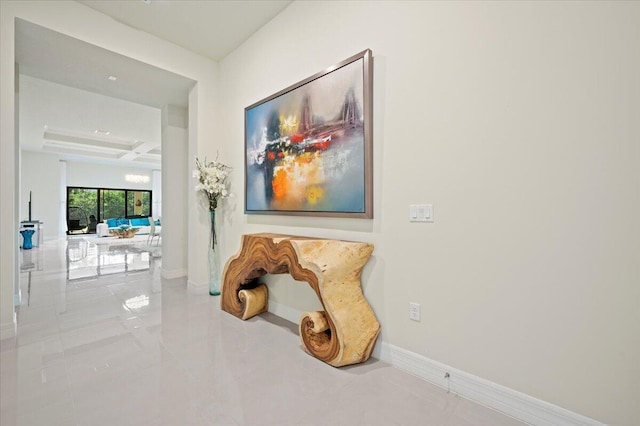 hall with baseboards, coffered ceiling, and beam ceiling