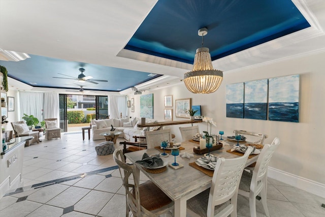 700 NE 20th Ln, Boynton Beach, FL 33435 - dining area featuring ceiling fan with notable chandelier, a tray ceiling, light tile patterned flooring, crown molding, and baseboards