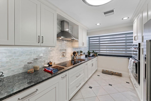 700 NE 20th Ln, Boynton Beach, FL 33435 - kitchen with visible vents, decorative backsplash, white cabinetry, wall chimney range hood, and black electric cooktop