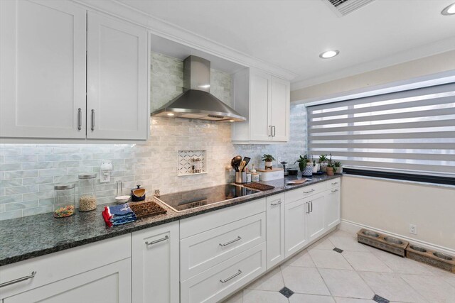 700 NE 20th Ln, Boynton Beach, FL 33435 - kitchen featuring light tile patterned flooring, ornamental molding, wall chimney range hood, black electric cooktop, and tasteful backsplash