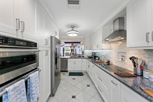 700 NE 20th Ln, Boynton Beach, FL 33435 - kitchen with visible vents, ornamental molding, decorative backsplash, appliances with stainless steel finishes, and wall chimney range hood