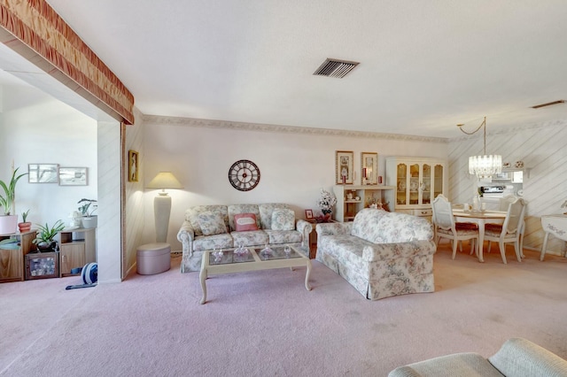 carpeted living room featuring a notable chandelier and visible vents