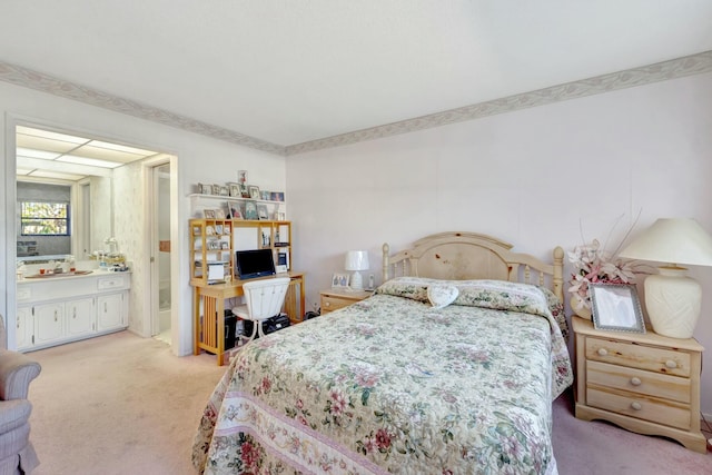 bedroom with ensuite bath and light colored carpet