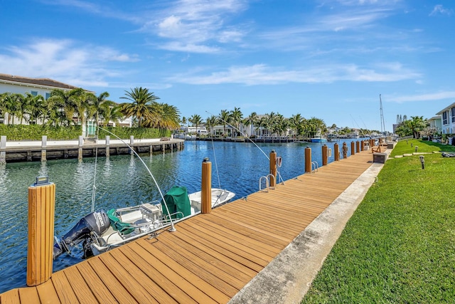 view of dock with a lawn and a water view