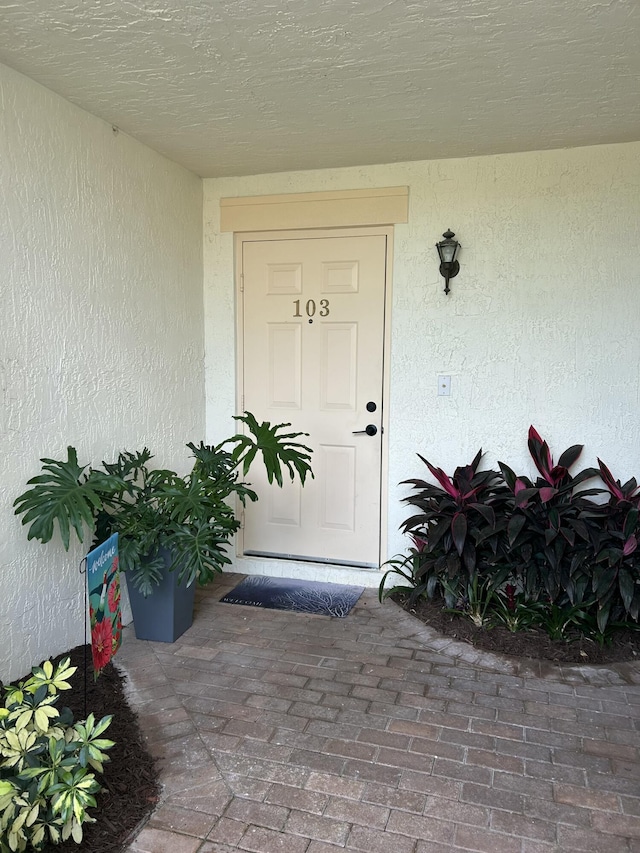 entrance to property with stucco siding