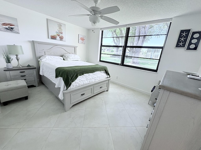 7365 NW 18th St Unit 107, Margate, FL 33063 - bedroom with multiple windows, a textured ceiling, ceiling fan, light marble finish floors, and baseboards