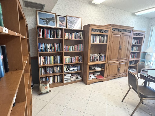 7365 NW 18th St Unit 107, Margate, FL 33063 - home office featuring light tile patterned flooring, a textured ceiling, wallpapered walls, a textured wall, and wall of books