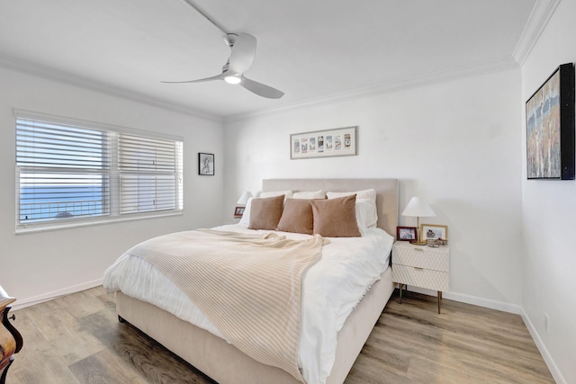 bedroom with wood finished floors, a ceiling fan, baseboards, and ornamental molding