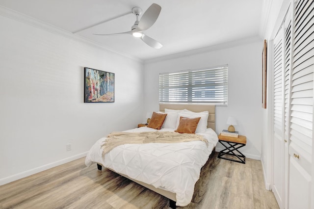 bedroom featuring ceiling fan, baseboards, light wood-style flooring, and crown molding