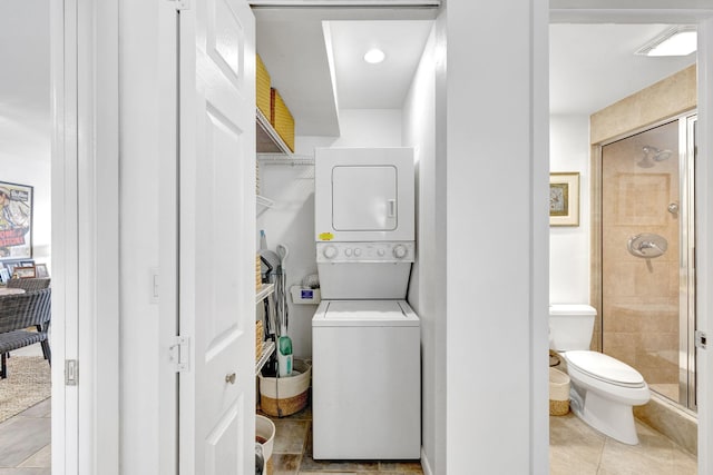 laundry room with light tile patterned floors, laundry area, and stacked washer and clothes dryer