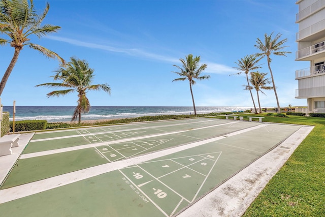 view of property's community with shuffleboard and a water view