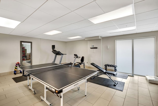 playroom featuring light tile patterned floors, a drop ceiling, and baseboards