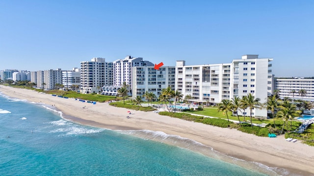 drone / aerial view featuring a water view, a view of city, and a view of the beach