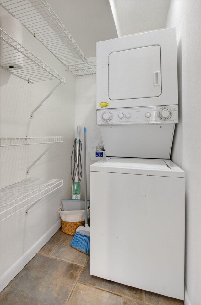 3101 S Ocean Blvd Unit 1002, Highland Beach, FL 33487 - washroom with stacked washing machine and dryer and baseboards