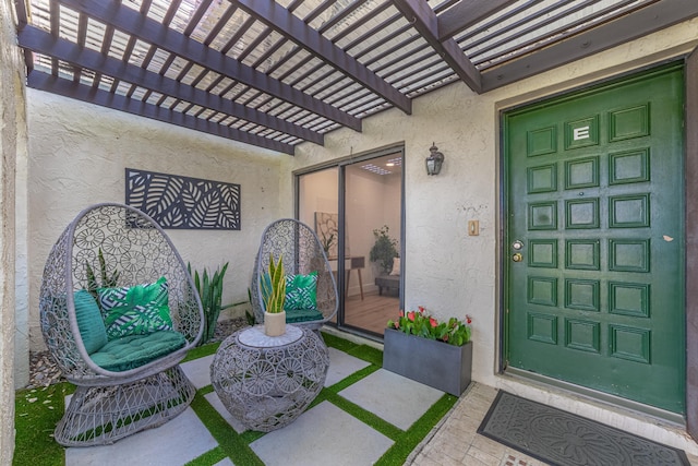 doorway to property featuring a pergola and stucco siding