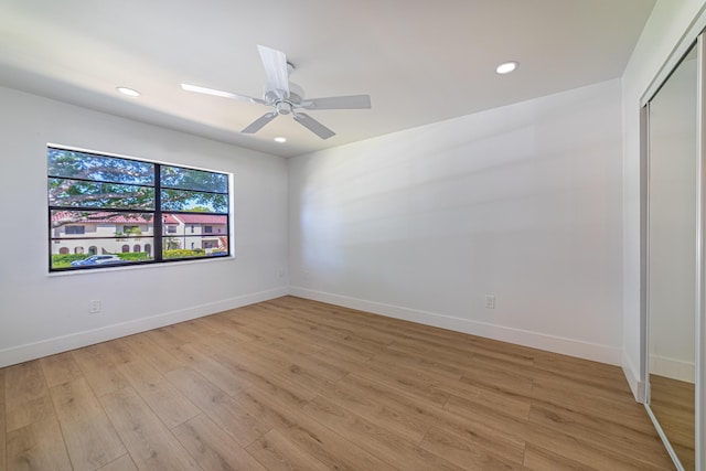 spare room featuring recessed lighting, light wood-type flooring, and baseboards