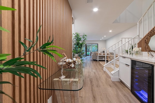 interior space with wine cooler, stairway, recessed lighting, and light wood finished floors