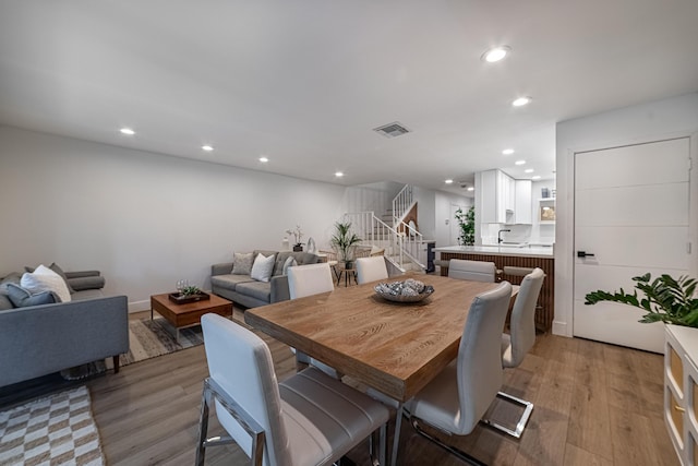 dining room featuring recessed lighting, visible vents, light wood-style floors, and stairway