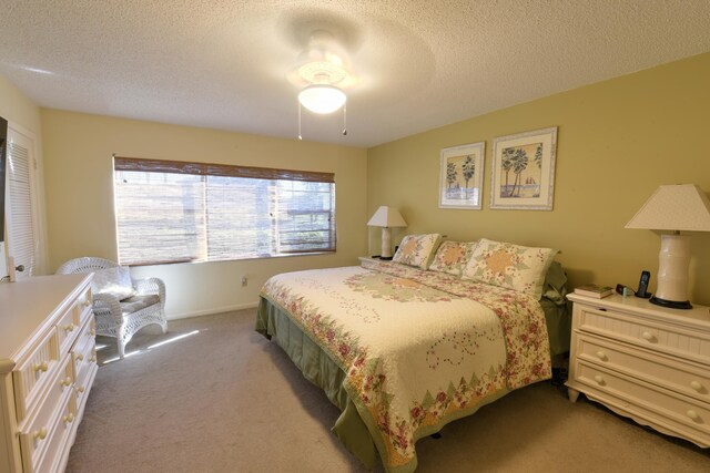15 Southport Ln Unit E, Boynton Beach, FL 33436 - bedroom with light carpet, a textured ceiling, and a ceiling fan