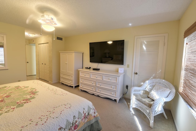 15 Southport Ln Unit E, Boynton Beach, FL 33436 - bedroom featuring a textured ceiling, visible vents, and light carpet