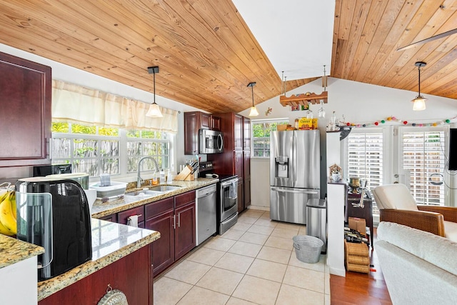 kitchen featuring a sink, pendant lighting, light tile patterned flooring, stainless steel appliances, and reddish brown cabinets