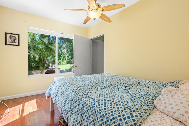 bedroom with a ceiling fan, baseboards, and wood finished floors