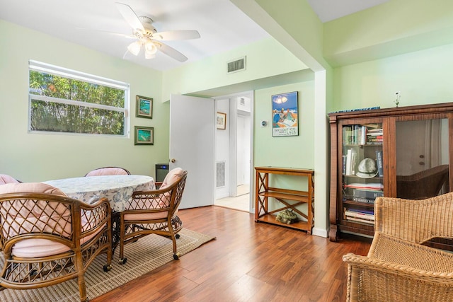 dining area with wood finished floors, visible vents, and ceiling fan