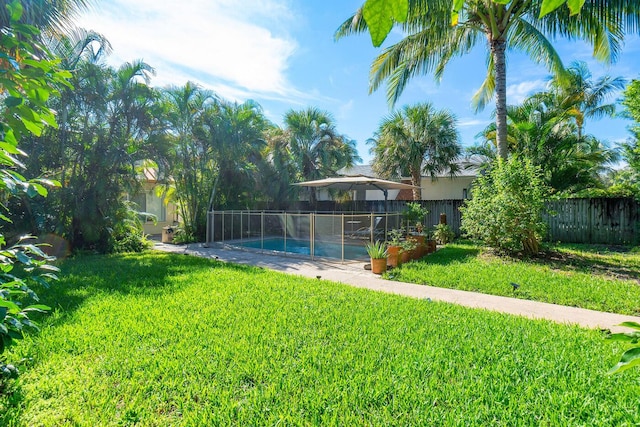 view of yard with a fenced in pool and fence