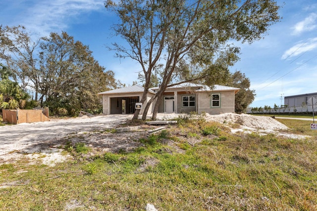 view of front facade featuring an attached garage, metal roof, driveway, and fence