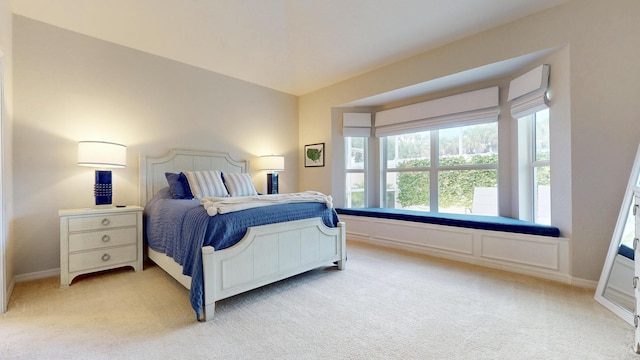 bedroom with baseboards and light colored carpet