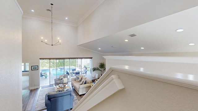 living area featuring visible vents, wood finished floors, recessed lighting, crown molding, and a chandelier