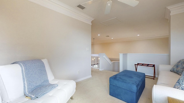 living area featuring a ceiling fan, visible vents, crown molding, carpet flooring, and an upstairs landing