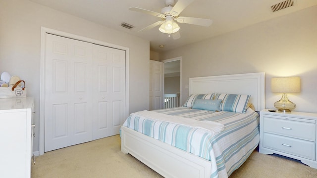 bedroom featuring a closet, visible vents, light colored carpet, and a ceiling fan