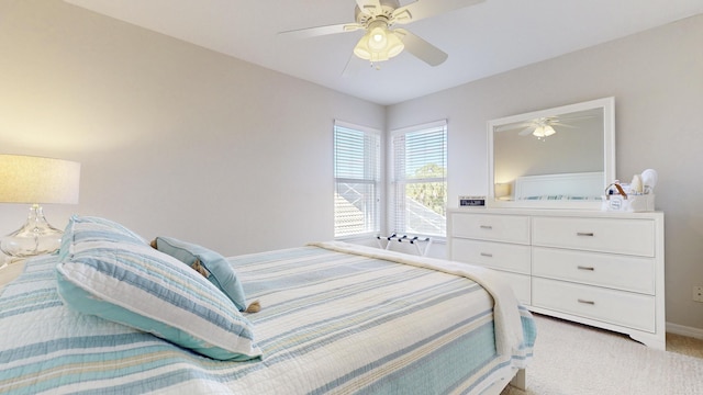 bedroom with ceiling fan, baseboards, and light carpet