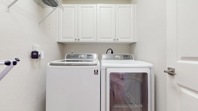 laundry room featuring cabinet space, independent washer and dryer, and a textured wall