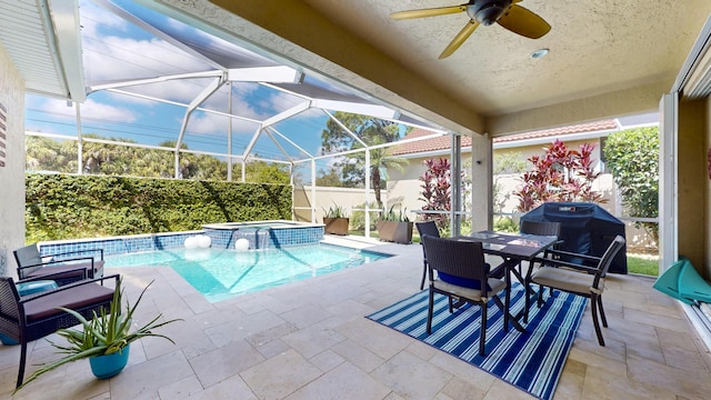 view of swimming pool with glass enclosure, outdoor dining space, a patio, area for grilling, and a ceiling fan