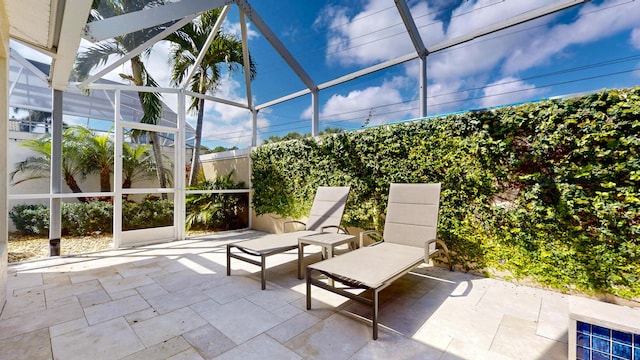 view of patio featuring glass enclosure