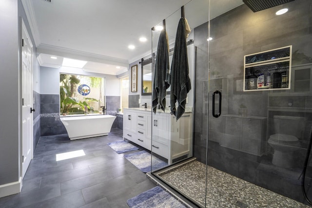 bathroom featuring tile walls, vanity, a shower stall, and crown molding