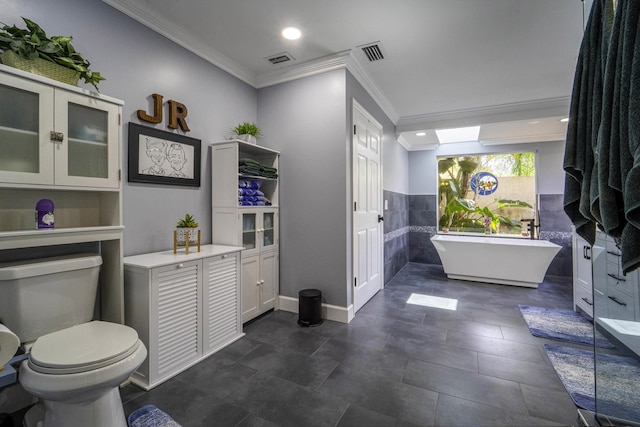 bathroom featuring a freestanding tub, visible vents, toilet, and crown molding