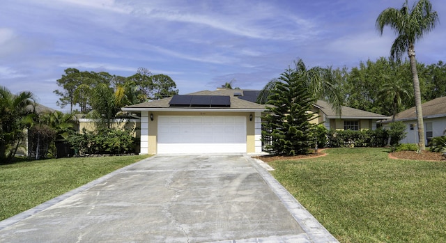 view of front of home featuring a front lawn, driveway, roof mounted solar panels, and stucco siding